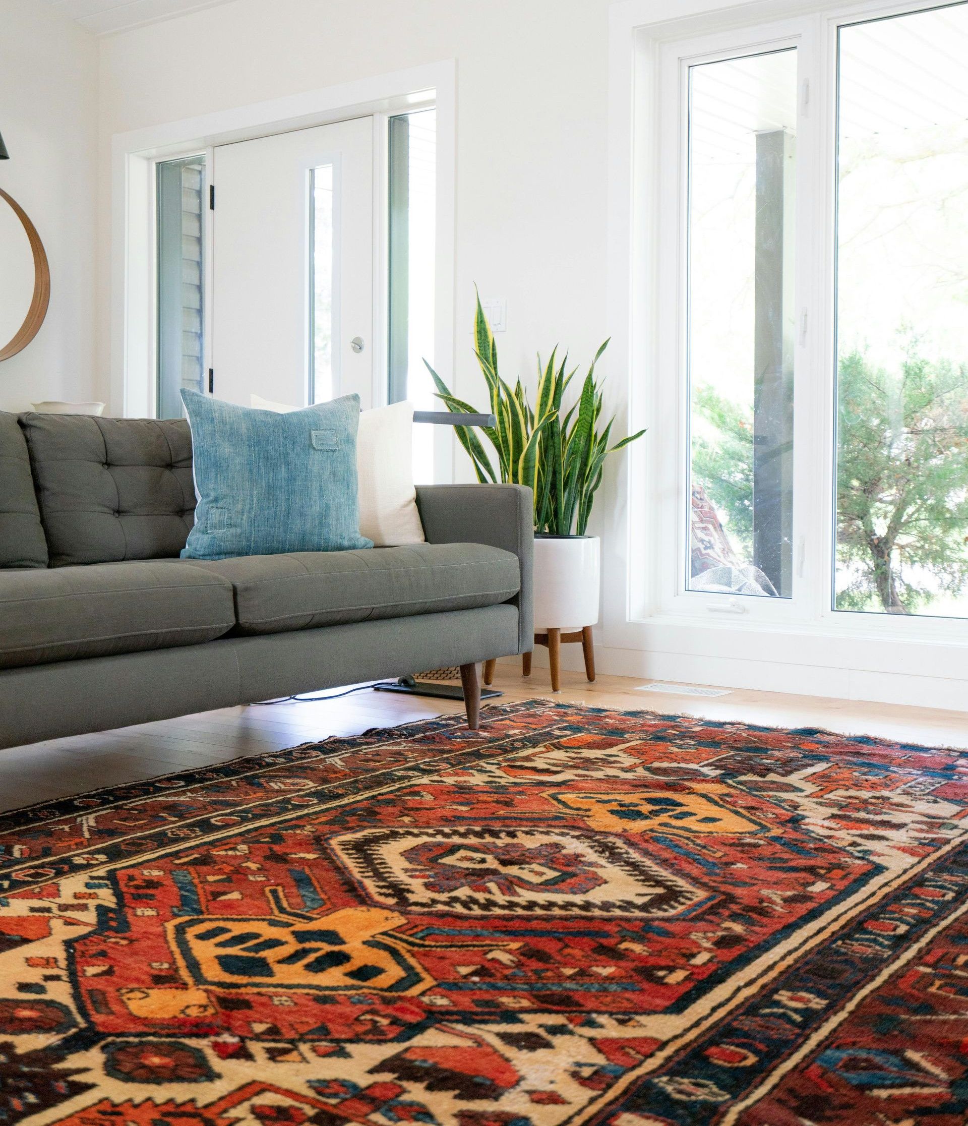 teal 2-seat couch and red area rug